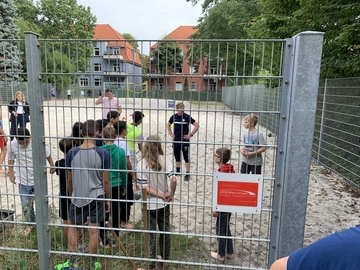 Die Schüler und Schülerinnen machen den Beachplatz sauber und spielen Sportspiele