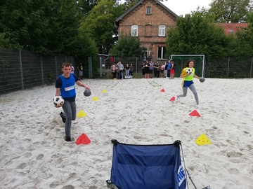 Die Schüler und Schülerinnen machen den Beachplatz sauber und spielen Sportspiele