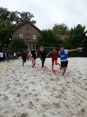 Die Schüler und Schülerinnen machen den Beachplatz sauber und spielen Sportspiele