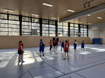 Die SchülerInnen spielen Basketball.