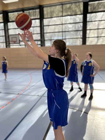 Die SchülerInnen spielen Basketball.