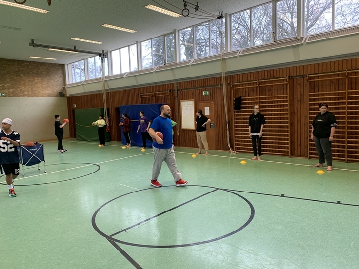 Die Schüler und Schülerinnen spielen Basketball.