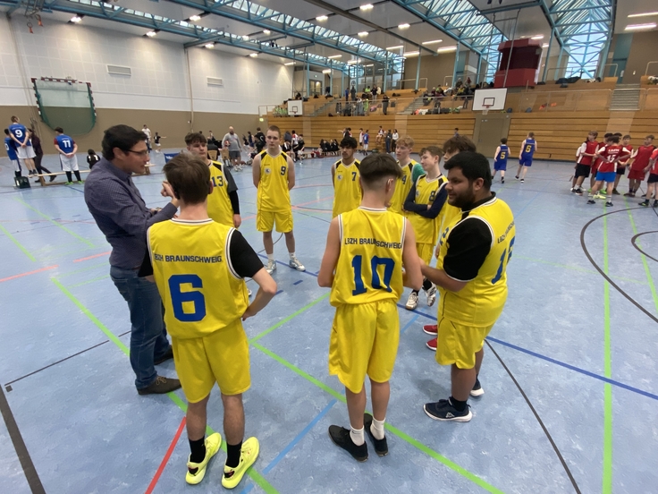 Die SchülerInnen spielen Basketball.